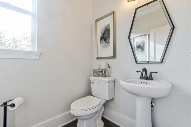a bathroom with a toilet sink and mirror