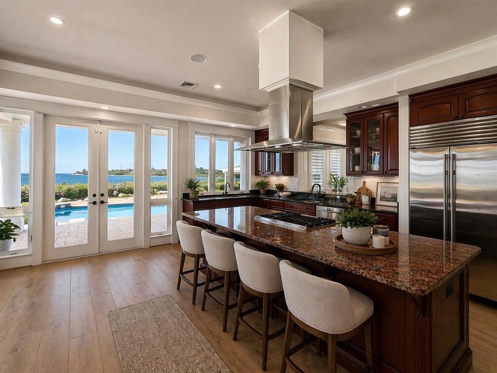 1721 Gulf Road Tarpon Springs, FL 34689 - Photo 11 of 96 a kitchen with granite countertop kitchen island a table and chairs in it