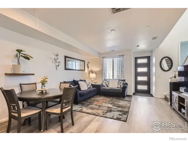 a living room with furniture a rug a lamp and a window