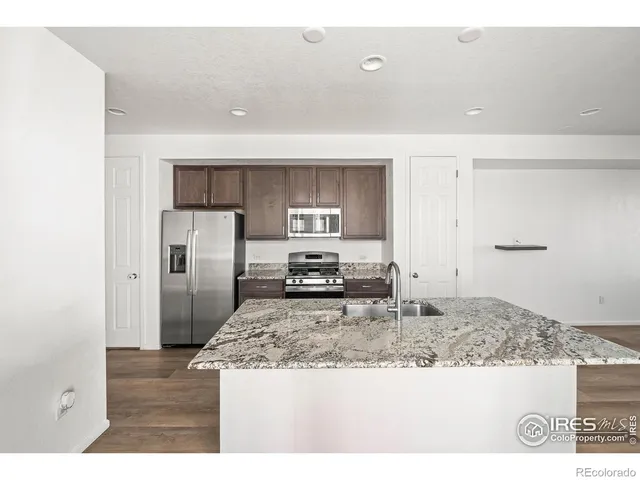 a kitchen with kitchen island a counter top and refrigerator