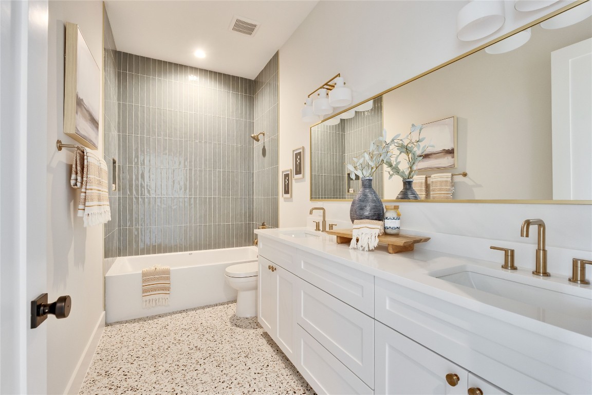 1937 East 38th 1/2 Street, Unit A Austin, TX 78723 - Photo 11 of 26 a bathroom with a double vanity sink toilet mirror and shower