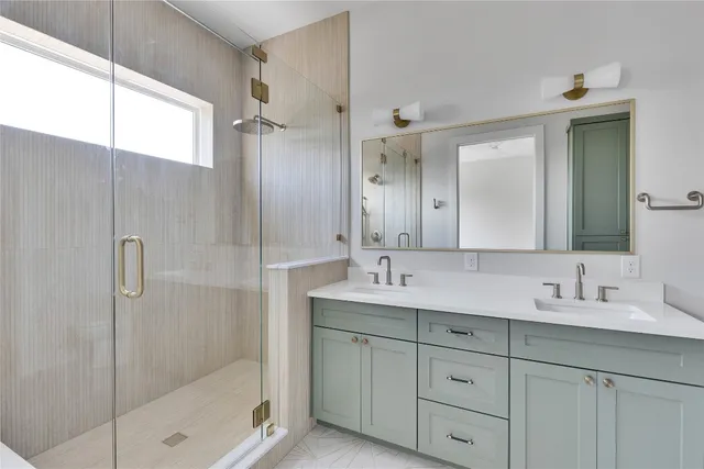 a bathroom with a double vanity sink mirror and shower