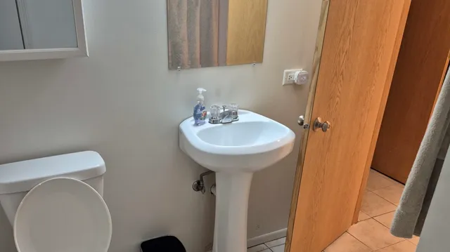 a bathroom with a sink toilet and a mirror