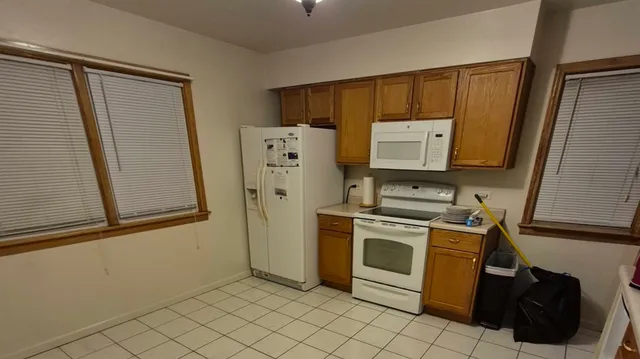 a kitchen with a refrigerator sink and cabinets