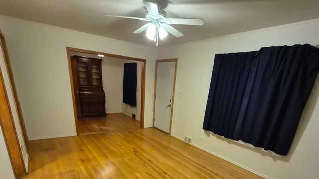 wooden floor in an empty room with a bathroom