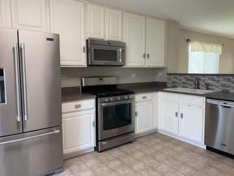 a kitchen with white cabinets and stainless steel appliances