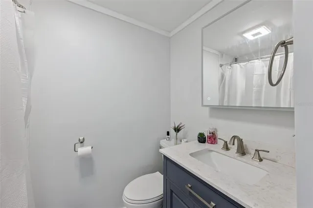 a bathroom with a granite countertop sink a toilet and a mirror