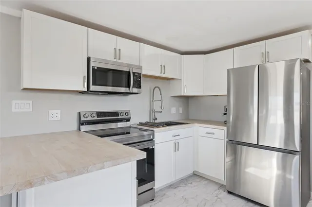 a kitchen with cabinets stainless steel appliances and a counter space