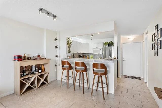a dining room with kitchen island and stainless steel appliances
