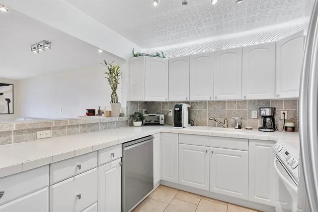 a kitchen with white cabinets sink and white appliances