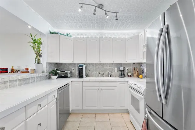 a kitchen with a sink a refrigerator and cabinets