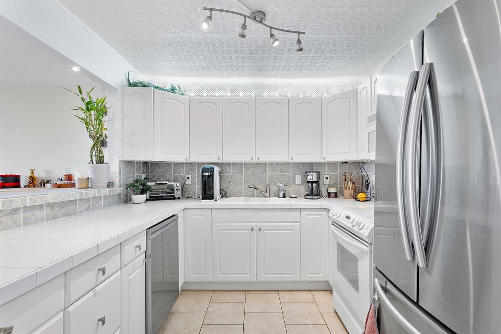 1800 North Andrews Avenue, Unit 9I Fort Lauderdale, FL 33311 - Photo 7 of 36 a kitchen with a sink a refrigerator and cabinets