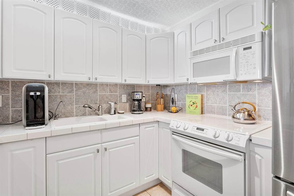 1800 North Andrews Avenue, Unit 9I Fort Lauderdale, FL 33311 - Photo 8 of 36 a kitchen with stainless steel appliances granite countertop white cabinets and a stove