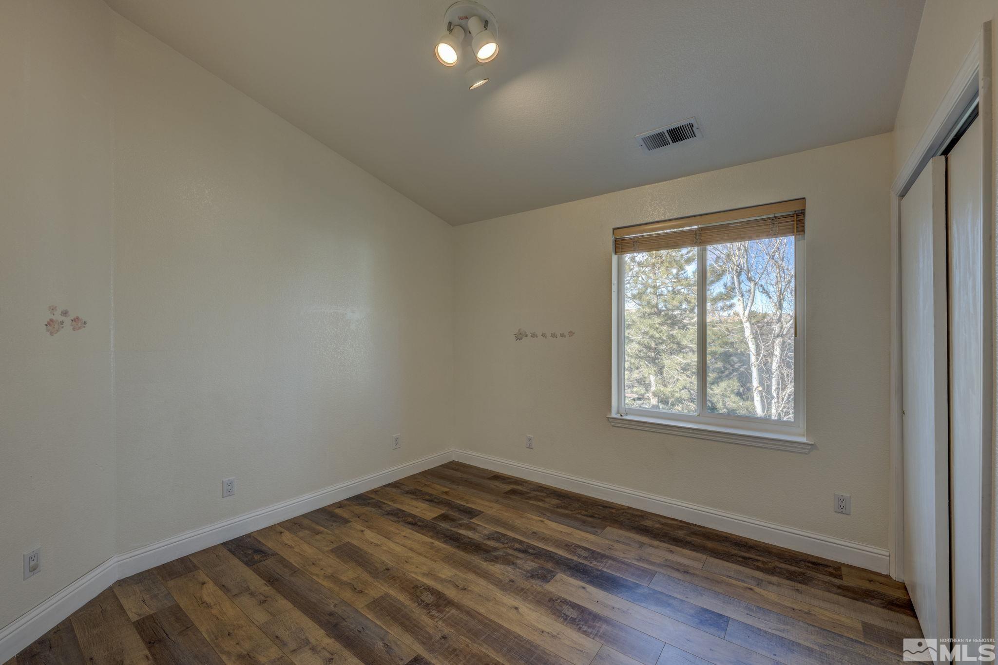 580 Creighton Way Reno, NV 89503 - Photo 26 of 40 an empty room with wooden floor and windows