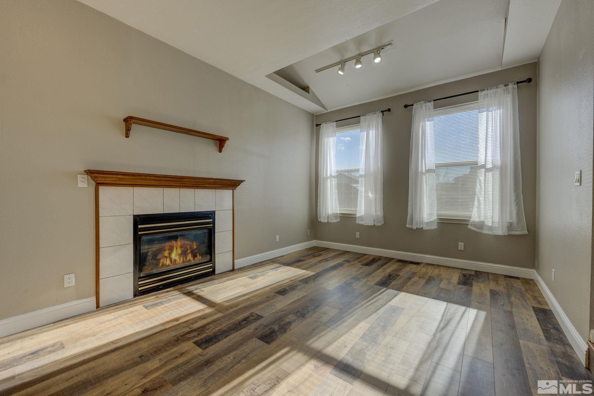 580 Creighton Way Reno, NV 89503 - Photo 9 of 40 a view of an empty room with wooden floor fireplace and a window