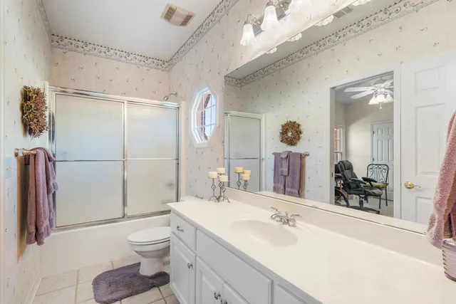a bathroom with a sink toilet vanity and shower