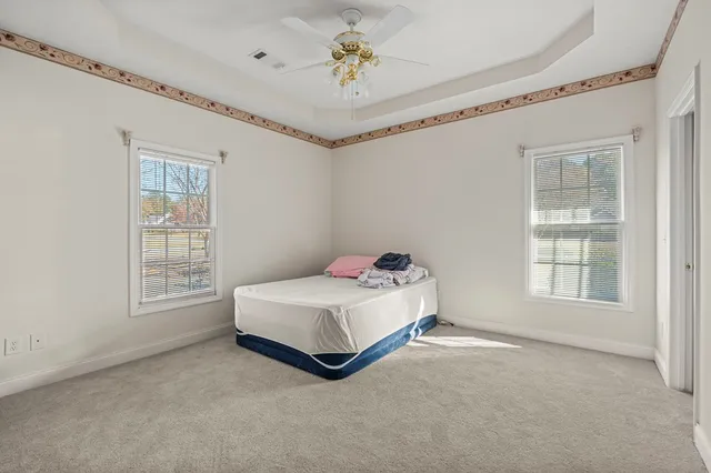a spacious bedroom with a bed and a chandelier