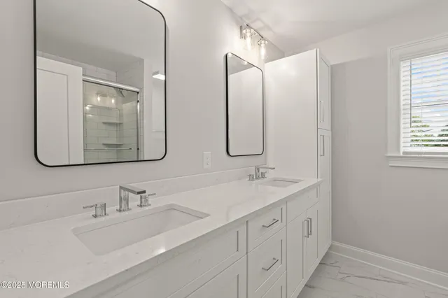 a bathroom with double vanity sinks and a mirror
