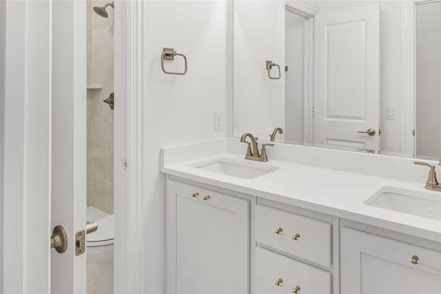 a view of a hallway with wooden floor and a bathroom