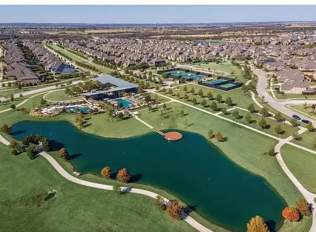 an aerial view of residential houses with outdoor space and swimming pool
