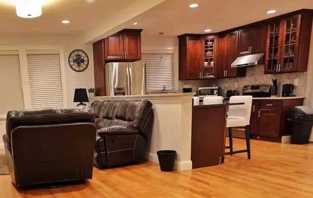 a living room with furniture a large window and wooden floors