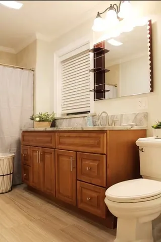 a bathroom with a granite countertop toilet sink and mirror