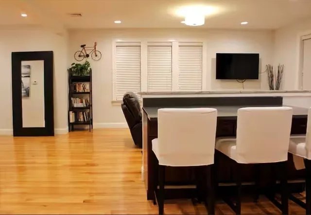 a kitchen with stainless steel appliances dining table chairs and a microwave