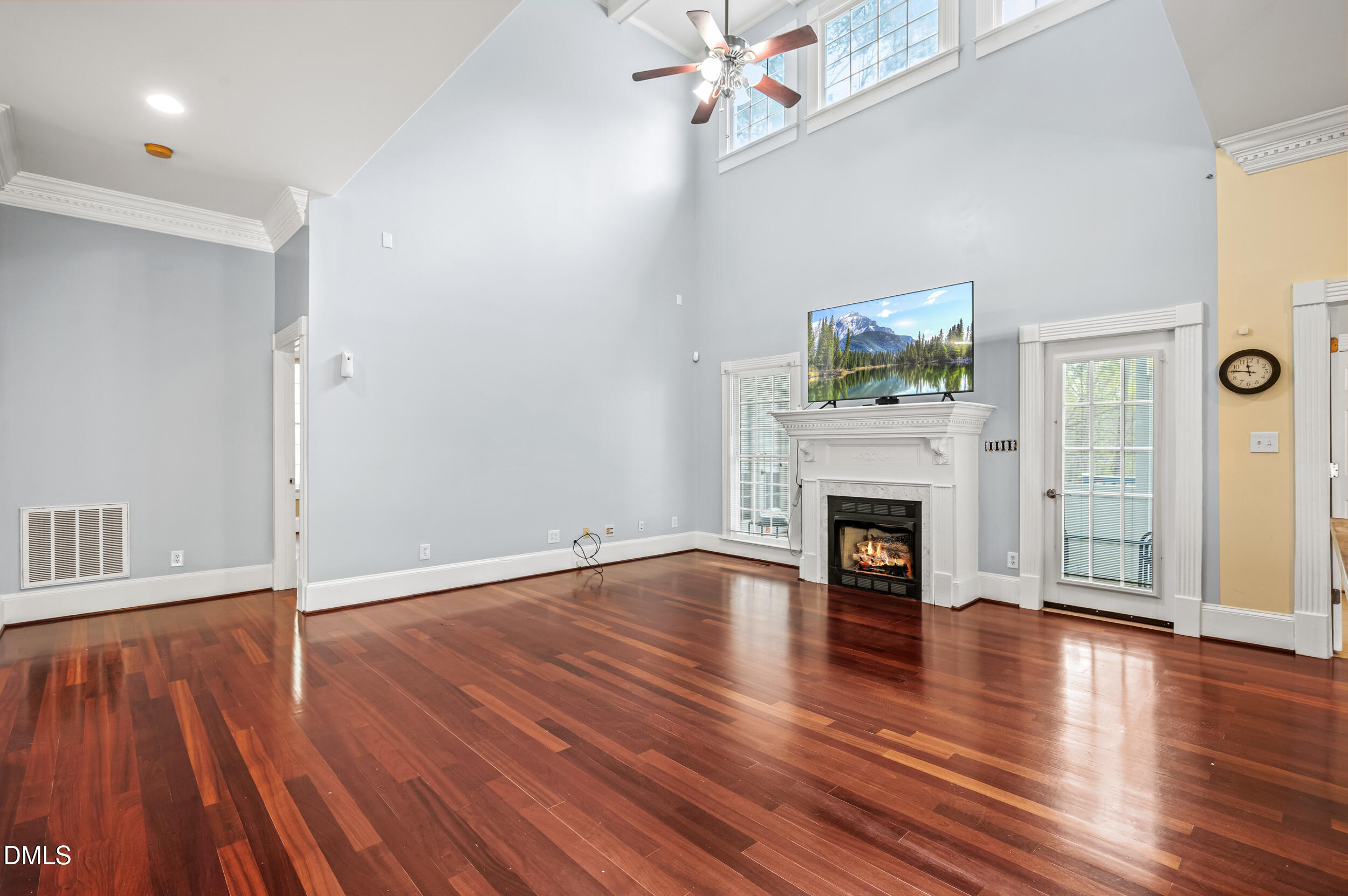 1957 Hilltop Road Raleigh, NC 27610 - Photo 12 of 46 an empty room with wooden floor fireplace and windows