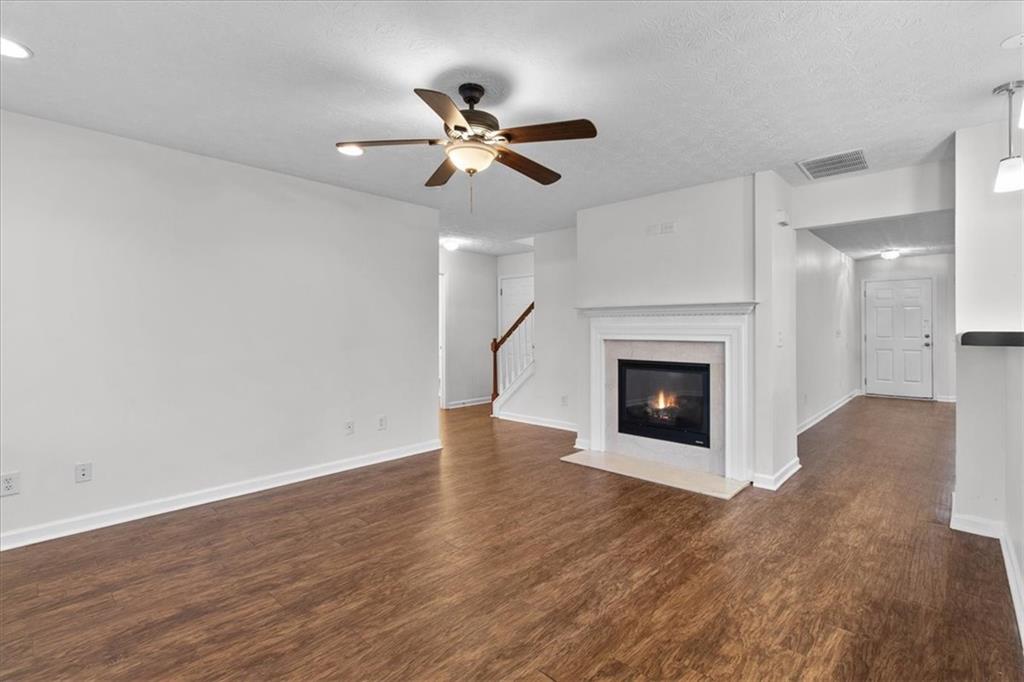 307 Meadows Lane Canton, GA 30114 - Photo 12 of 33 a view of an empty room with wooden floor fireplace and a window
