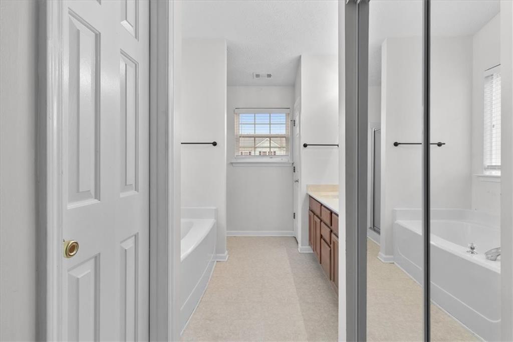307 Meadows Lane Canton, GA 30114 - Photo 19 of 33 a bathroom with a bathtub sink and mirror