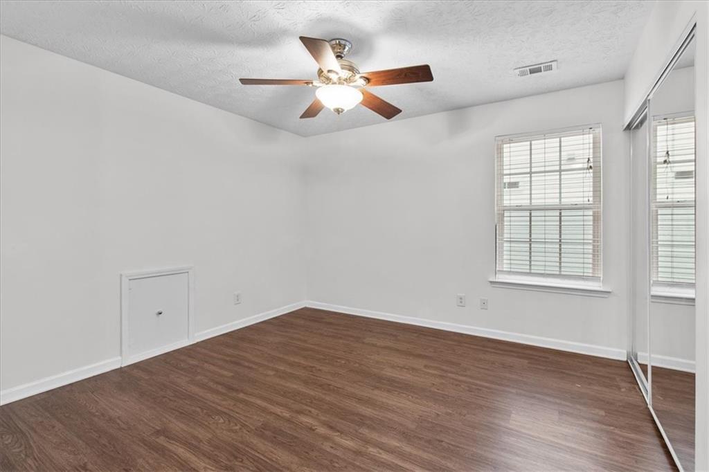 307 Meadows Lane Canton, GA 30114 - Photo 27 of 33 an empty room with wooden floor fan and windows