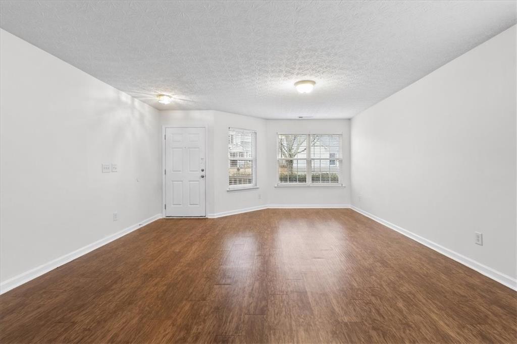 307 Meadows Lane Canton, GA 30114 - Photo 5 of 33 an empty room with wooden floor and windows