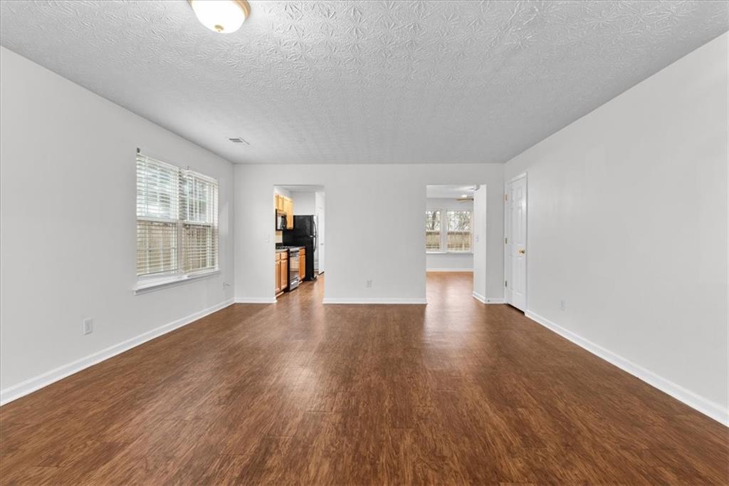307 Meadows Lane Canton, GA 30114 - Photo 6 of 33 a view of an empty room with window and wooden floor