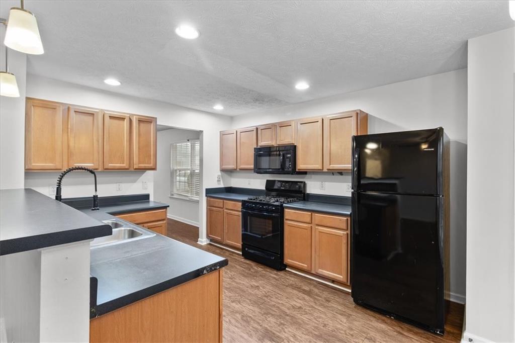 307 Meadows Lane Canton, GA 30114 - Photo 8 of 33 a kitchen with stainless steel appliances granite countertop a refrigerator a sink dishwasher a stove and white countertops with wooden floor