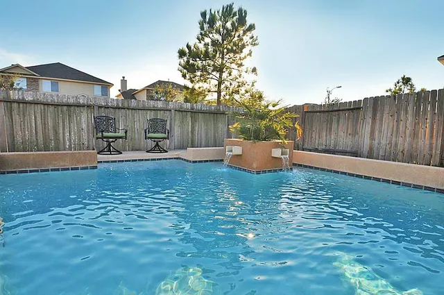 a backyard of a house with table and chairs