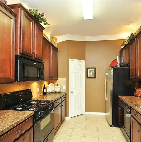 a kitchen with granite countertop a stove and a refrigerator