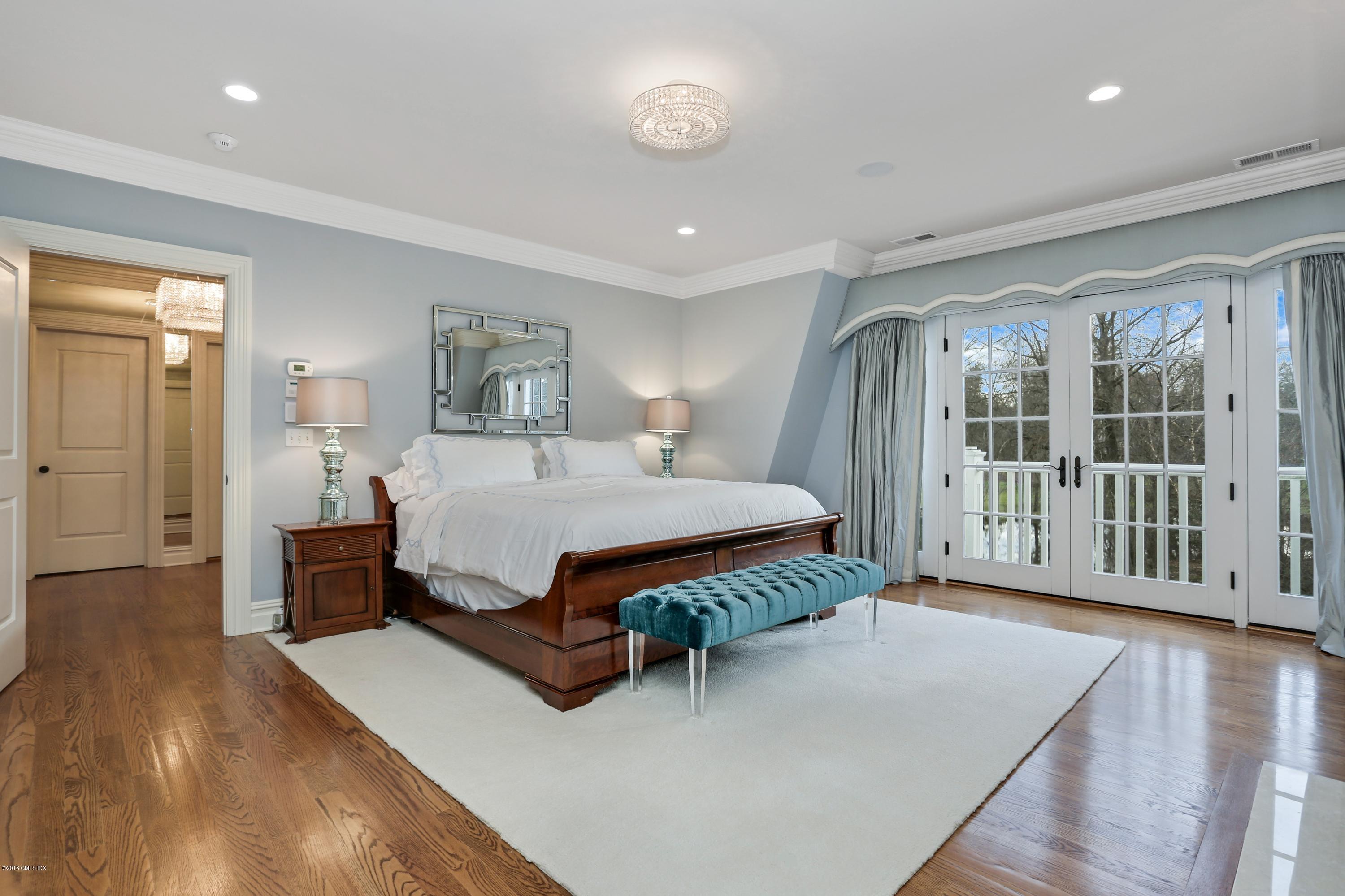 10 Andrews Road Greenwich, CT 06830 - Photo 14 of 29 a spacious bedroom with a large bed and a wooden floor