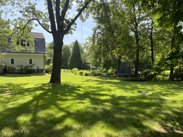10 Andrews Road Greenwich, CT 06830 - Photo 26 of 29 a swimming pool with a yard and trees