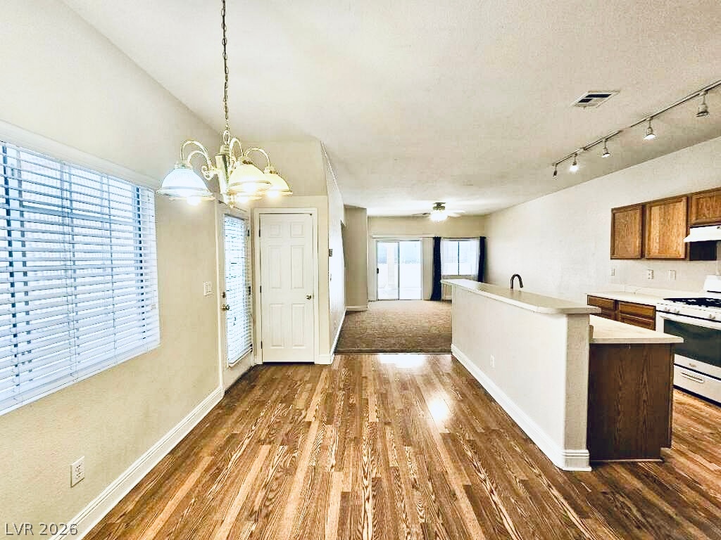 5953 Crumbling Ridge Street Henderson, NV 89011 - Photo 4 of 42 Hardwood floors stretch across this open-concept living space, leading to a modern kitchen.