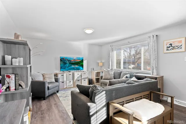 a living room with furniture a flat screen tv and a large window