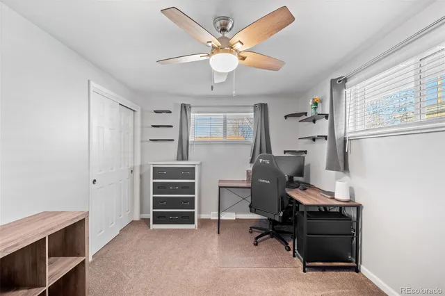 an empty room with windows and fan