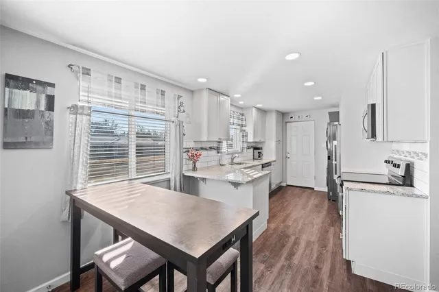 a kitchen with kitchen island a wooden floor and white appliances