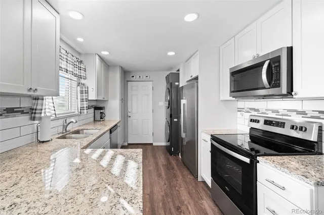 a kitchen with stainless steel appliances kitchen island granite countertop a stove sink and microwave