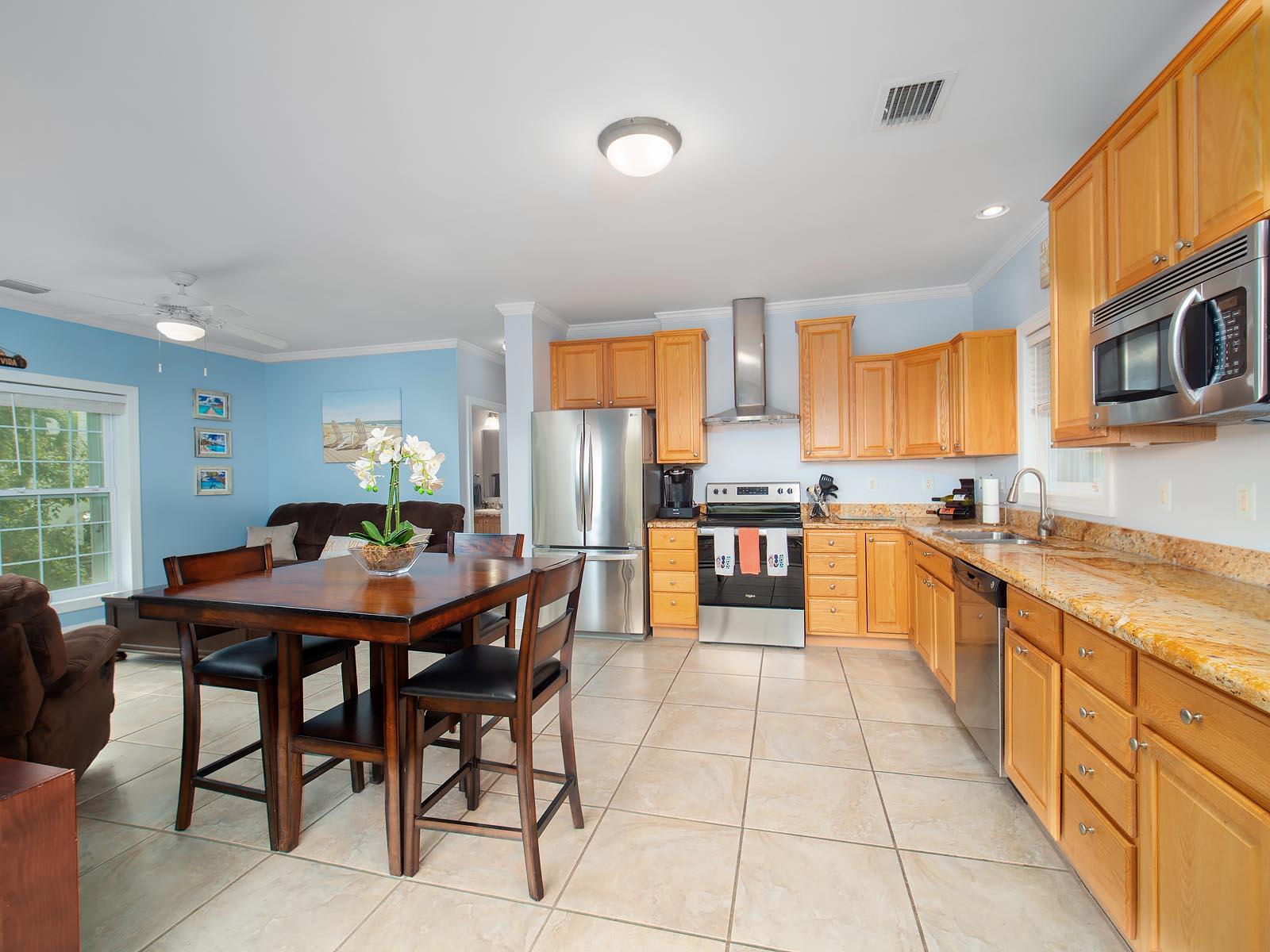 83 Palm Drive Key West, FL 33040 - Photo 4 of 35 a kitchen with stainless steel appliances kitchen island granite countertop a table chairs sink and cabinets
