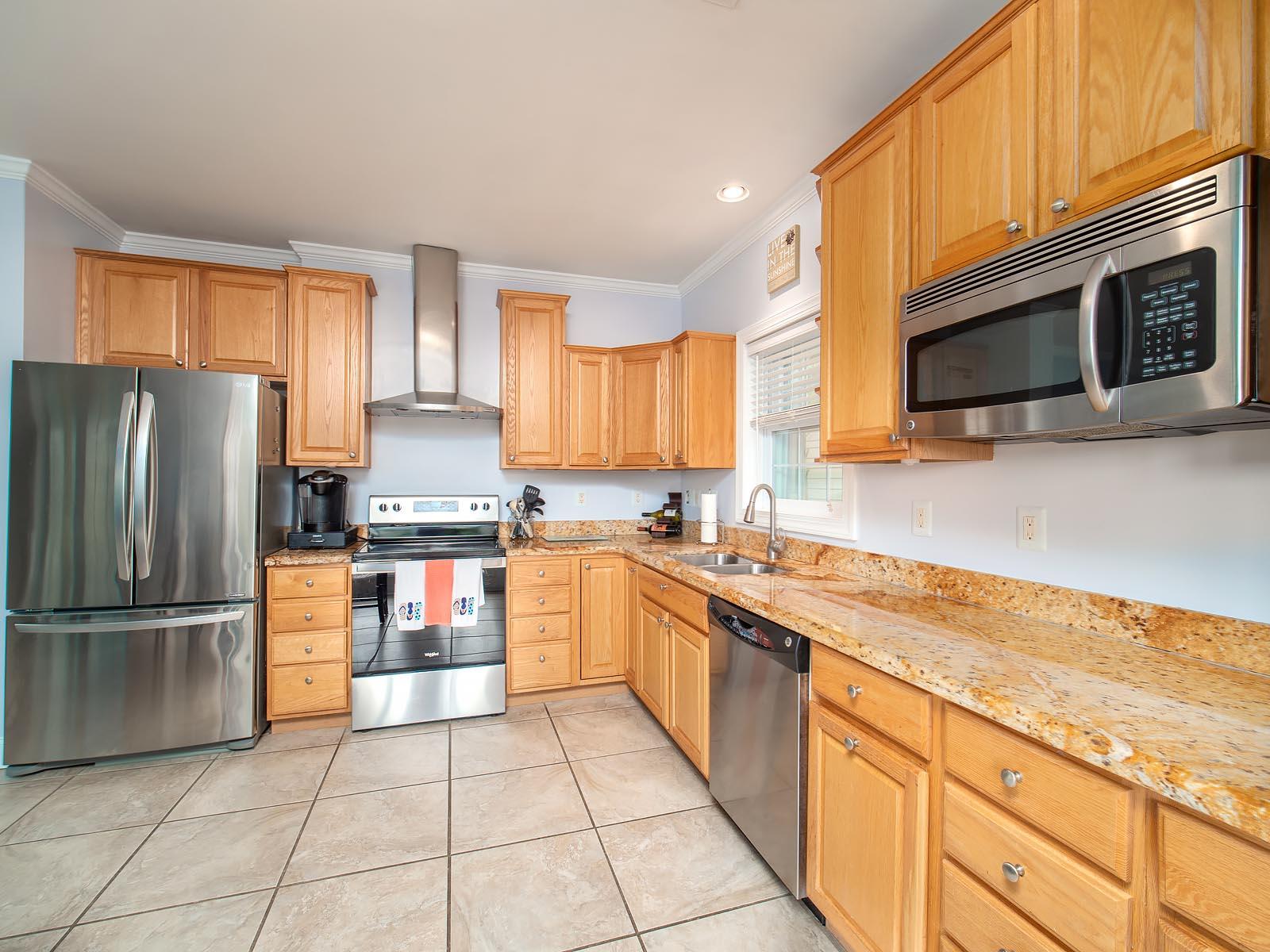 83 Palm Drive Key West, FL 33040 - Photo 5 of 35 a kitchen with stainless steel appliances granite countertop a refrigerator sink and microwave