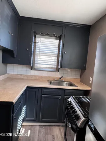 a kitchen with a sink a stove and cabinets