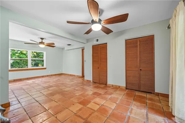 a view of an empty room with a window and cabinet