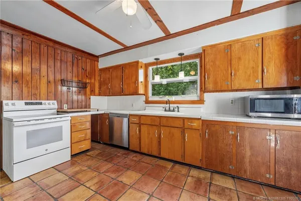a large kitchen with stainless steel appliances granite countertop a refrigerator and a sink