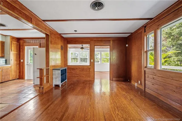 an empty room with windows and fan