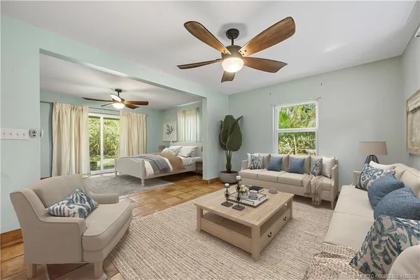 a living room with furniture a large window and a chandelier